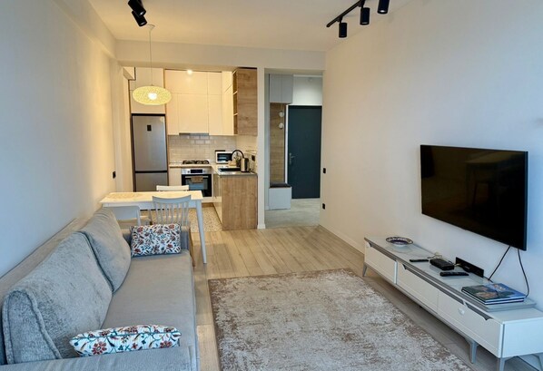 A modern apartment with a living room, kitchenette, and a dining area. - Cozy minimalistic apartment in Bagebi (T'bilisi)
