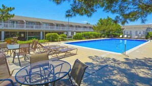 A hotel with a swimming pool, outdoor seating, and a covered patio area. - Canal View Townhouse w/Private Deck, Washer/Dryer, & Private Balcony (Ocean City)