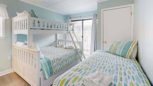 Un dormitorio con literas, una puerta y una ventana.