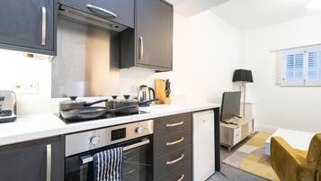 A compact kitchen with a stove, oven, and modern cabinetry.