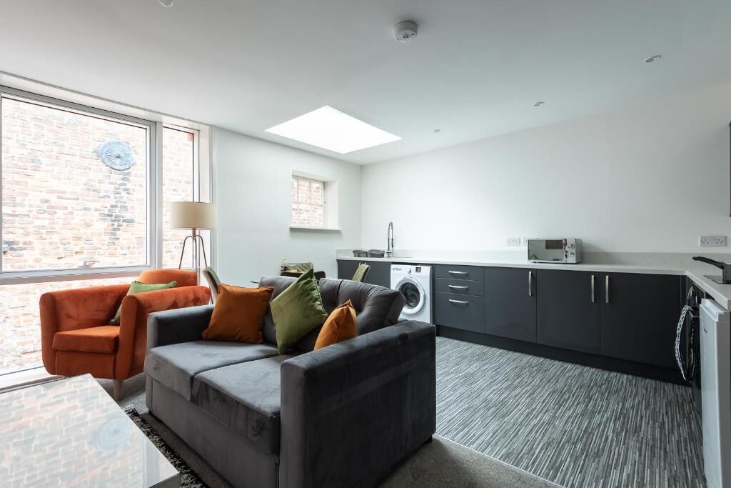 Eine moderne Wohnung mit Wohnbereich, Küche und Waschmöglichkeiten.