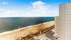 A high-rise building with a view of a beach and ocean. - Cozy beachfront condo with balcony views, pools & game room (Ocean City)