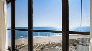 Ein großes Fenster mit Blick auf einen Strand und einen Parkplatz.