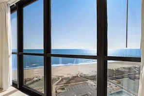 Ein großes Fenster mit Blick auf einen Strand und einen Parkplatz.