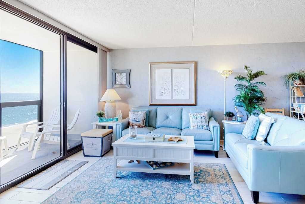 Un salón moderno con sof á, mesa de centro y vista a través de un ventanal.