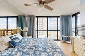 A bedroom with a bed, a ceiling fan, a TV, and large windows with curtains. - Stunning beachfront condo with balcony, tennis/beach views, pools, gym, & AC (Ocean City)