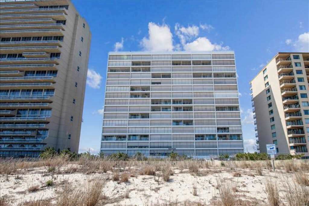 A modern building with multiple floors, large windows, and a flat roof.