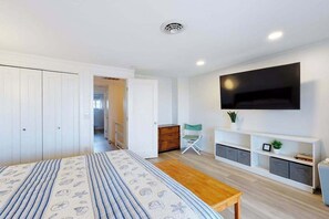 A bedroom with a bed, a TV, a desk, and a wardrobe. - Multi-level oceanfront townhouse w/deck, water views, central AC, washer/dryer (Ocean City)
