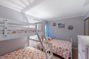 A room with bunk beds, a white dresser, and a small table. - Family-Friendly Condo w/Private Balcony, Washer/Dryer, Cable, and Central A/C (Ocean City)