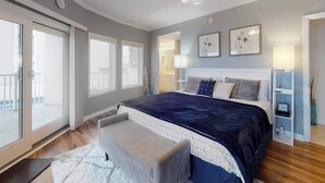 Un dormitorio con una cama grande, ventilador de techo y vistas al exterior.