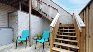 A wooden staircase leading to a deck, two chairs, and a covered patio area. - Club Ocean Villa II 97 (Ocean City)