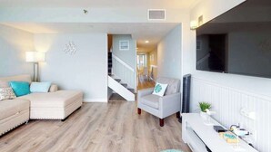 A living room with a sofa, armchair, and a flat-screen TV. - Beautiful Condo in Oceanfront Location w/Shared Pool, Free WiFi, Balcony (Ocean City)