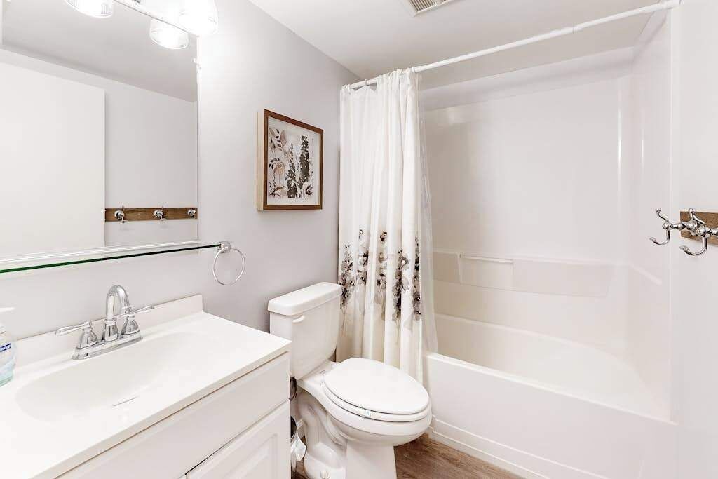Une salle de bain avec un lavabo, des toilettes et une baignoire, le tout de couleur blanche.
