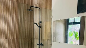Casa de banho moderna com duche, sanita e toucador com cestos.