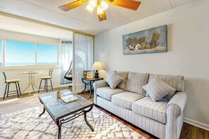 A living room with a sofa, coffee table, and artwork on the wall. - Fun-Filled Vacation Condo in Beachfront Complex w/Shared Pool, Free WiFi (Ocean City)