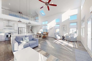 A spacious living area with a high ceiling fan, a dining table, and a sofa. - Atlantic Blvd 13314 (Ocean City)
