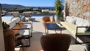A terrace with outdoor furniture, a pool, and a view of the sea and hills. - Guest Room “Chambre Albatre” with Sea View, Wi-Fi and Air Conditioning (Palasca)