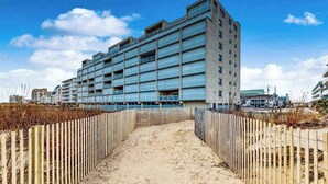 En byggnad med flera våningar och en modern arkitektonisk design, med en rad balkonger och stora fönster.