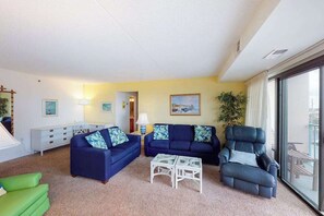 A living room with two sofas, a chair, a coffee table, a lamp, and a painting on the wall. - Beachfront Condo w/Private Balcony, Shared Pool, Ocean Views, Free WiFi, A/C (Ocean City)