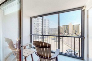 Ein Balkon mit Blick auf einen Parkplatz und Gebäude.