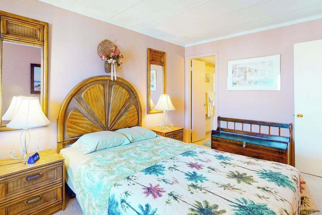 Una camera da letto con un letto, comodini, uno specchio e una porta.