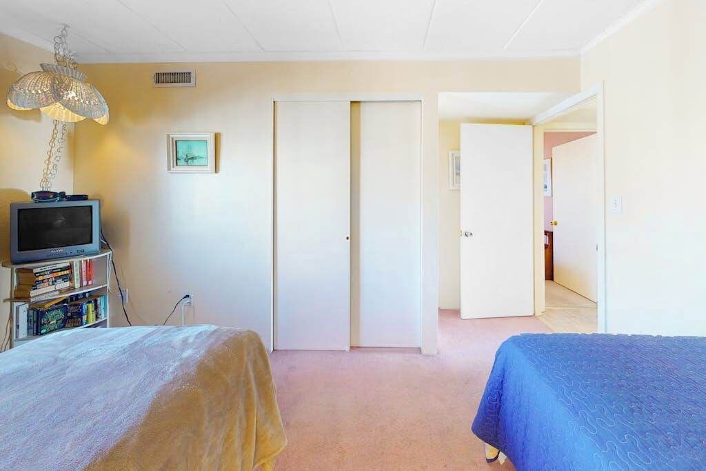 Una camera da letto con un letto, una televisione, una libreria e un armadio.