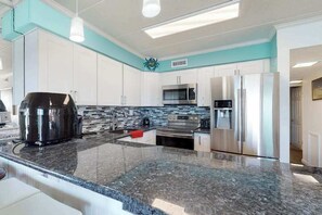 A modern kitchen with granite countertops, stainless steel appliances, and white cabinetry. - Terrific Suite in Bayfront Complex w/Shared Pool, Free WiFi, Central AC, Balcony (Ocean City)