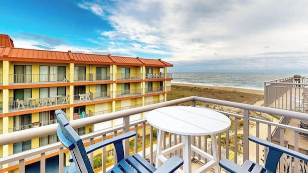 Un balcón de hotel con vista a la playa y al océano.
