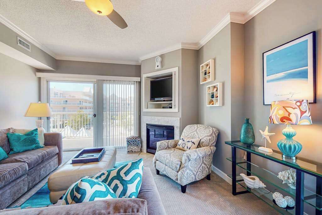 A living room with a sofa, armchair, fireplace, television, and decorative items.