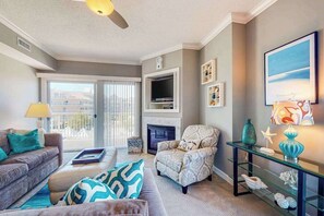 Ein Wohnzimmer mit Sofa, Sesseln, Kamin, Fernseher und Dekoration.