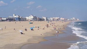 A beach with buildings in the background, sandy beach, and ocean waves. - Bahia Vista I 403 (Ocean City)