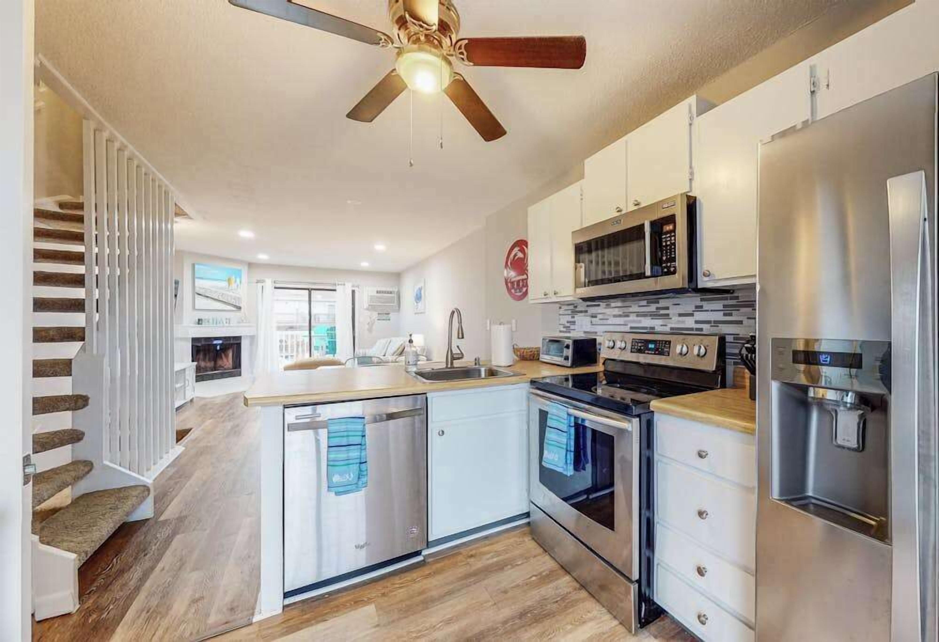 A modern kitchen with a central island, built-in oven, microwave, and refrigerator.