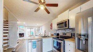 A modern kitchen with a central island, built-in oven, microwave, and refrigerator. - Canal-front townhome with front/back decks, shared pool, private w/d, & WiFi (Ocean City)