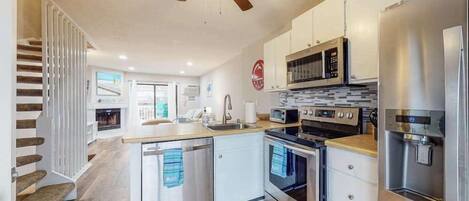 A modern kitchen with a central island, built-in oven, microwave, and refrigerator.