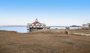 Ein Küstengebäude mit Leuchtturm, einer Pier und einem Gewässer.