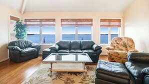 A living room with a sofa, armchair, and a coffee table. - A Bayfront Row Seat (Ocean City)