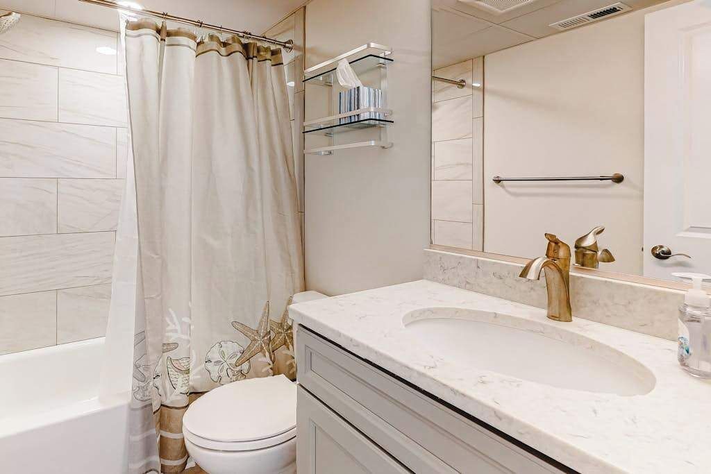 A bathroom with a bathtub, toilet, and sink.