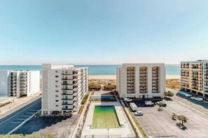 A high-rise building with a swimming pool and a view of the beach. - Fantastic Condo Situated in Oceanfront Complex w/Shared Pool, Free WiFi, AC (Ocean City)