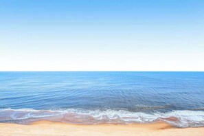 Ein Strand mit klarem, blauem Wasser und einem sandigen Ufer.