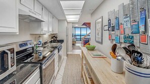 A modern kitchen with white cabinetry, a microwave, and a coffee machine. - 22nd-Floor Oceanfront Gem with Three Balconies, W/D, AC, and Shared Heated Pool (Ocean City)