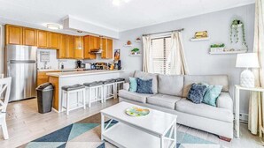 A compact living space with a kitchenette, a sofa, a coffee table, and a dining area. - Condesa 201 (Ocean City)