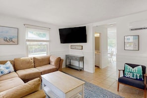 A living room with a beige sofa, a coffee table, a TV, and a sign that reads 'OCEAN CITY'. - Quiet townhome 3 blocks from beach with balcony, AC, & W/D - near bars/dining (Ocean City)