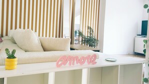 Un salon moderne avec un mur à rayures, un canapé, une table basse et une plante en pot.