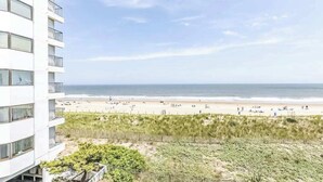 Ein Hotel direkt am Strand mit Blick auf den Ozean, einem Sandstrand und einer Dünenlandschaft.