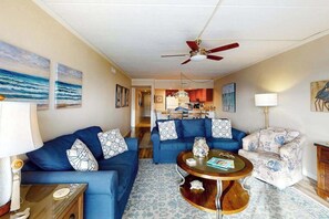 A living room with two sofas, a coffee table, and a patterned armchair. - Coastal Condo w/Side Ocean Views, Balcony, Shared Pool, Private W/D, Free WiFi (Ocean City)