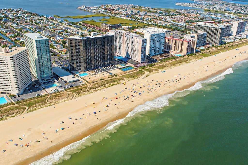 Ein Küstenhotelbereich mit Hochhäusern, einem Sandstrand und Blick auf den Ozean.