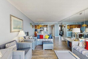 Ein Wohnzimmer mit einer Couch, einem Couchtisch und einem Essbereich mit Tisch und Stühlen.