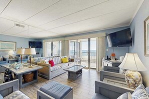 A spacious living room with a sofa, coffee table, and TV. - Breakaway East 512 (Ocean City)