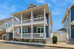 A two-story house with a balcony, a porch, and a 'RENT' sign. - Large two-level home with two kitchens, two decks, fast WiFi, & great location (Ocean City)