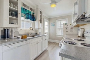 A kitchen with white cabinets, a dishwasher, a stove, and a window with blinds. - Family-Friendly Compound with Balcony, Porch, Grill, & WiFi - Walk to Beach (Ocean City)